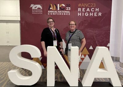 Staff standing in front of a sign that reads ANC.
